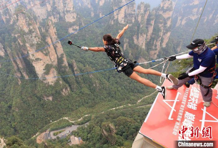 户外运动爱好者张家界峰林间挑战高空荡绳