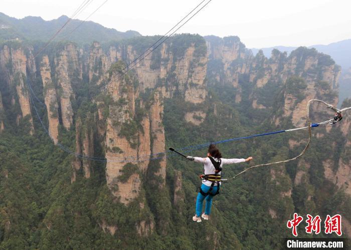 户外运动爱好者张家界峰林间挑战高空荡绳