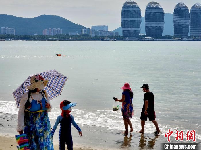 12月10日，三亚湾，市民游客从海边走过。　王晓斌 摄