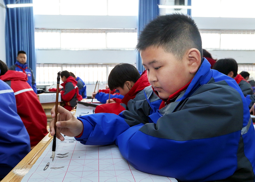 课堂上，同学们练习书写甲骨文。牛文堂摄