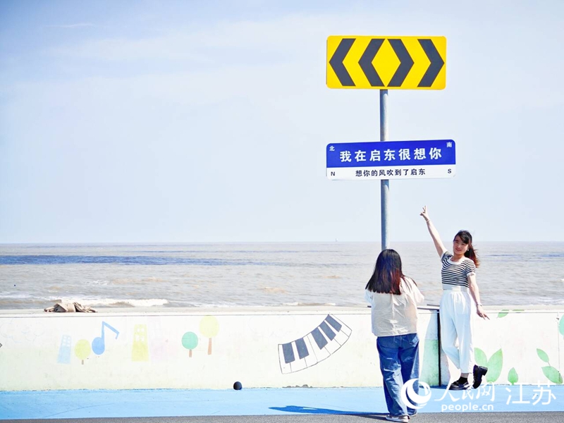 江苏启东,一座“追光”的城市 游客在海边拍照打卡。人民网记者 王继亮摄