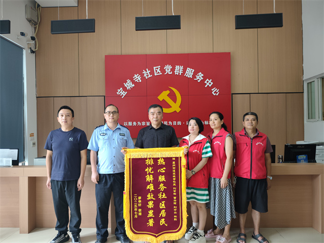 居民廖先生为宝城寺社区民警、网格员送锦旗致谢。通讯员 王轩 摄