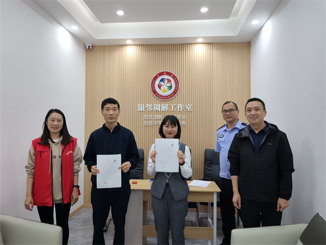 社区民警、网格员成功调解谢先生与李女士矛盾纠纷，双方握手言和。通讯员 王轩 摄