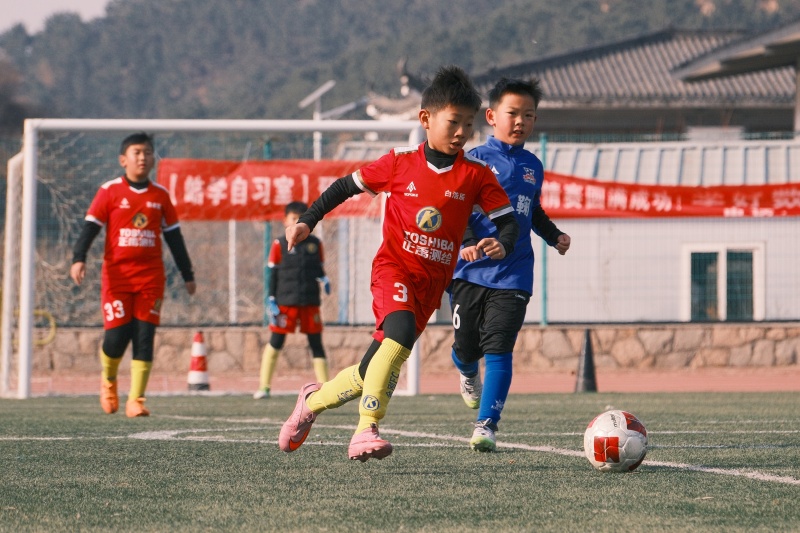 山东青岛:足球贺岁启新程 2026年1月1日,在山东省青岛市城阳区夏庄街道山色峪乡村振兴齐鲁样板省级片区举办的足球邀请赛上,足球小将在带球进攻。