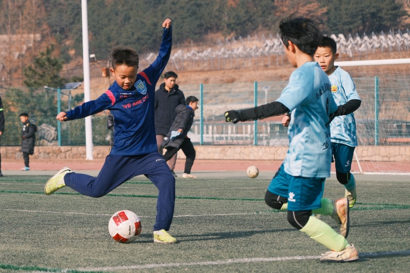 山东青岛:足球贺岁启新程 2026年1月1日,在山东省青岛市城阳区夏庄街道山色峪乡村振兴齐鲁样板省级片区举办的足球邀请赛上,足球小将在大力射门。