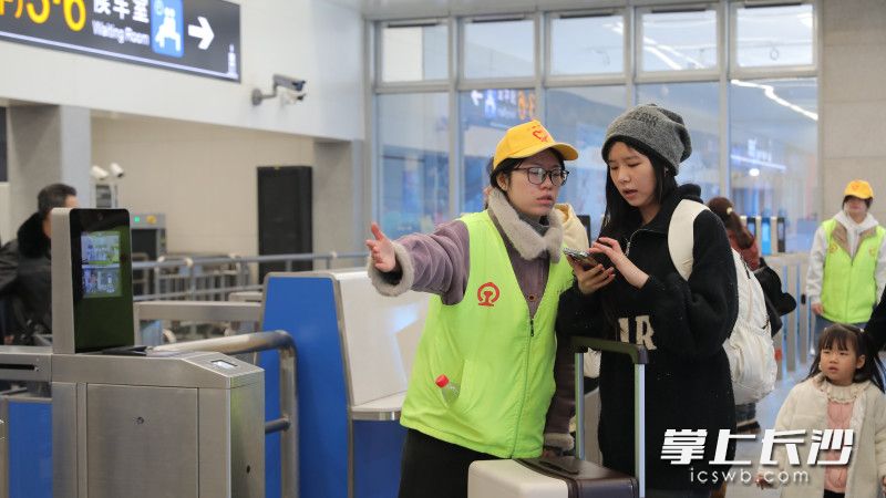 志愿者指引旅客入站。