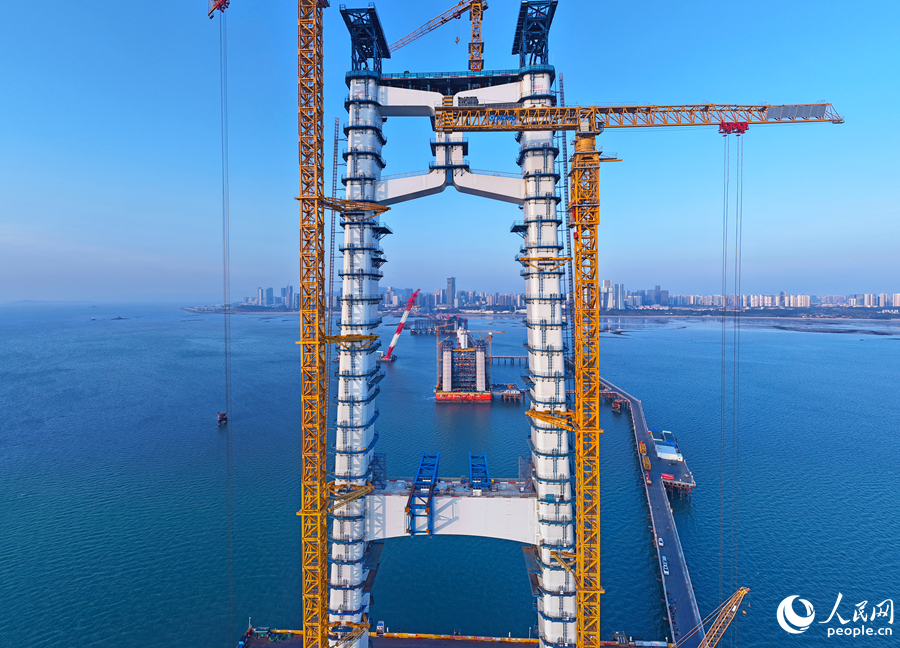 晨曦中的西主塔，矗立在波光粼粼的海面上。人民网记者 李昌乾摄