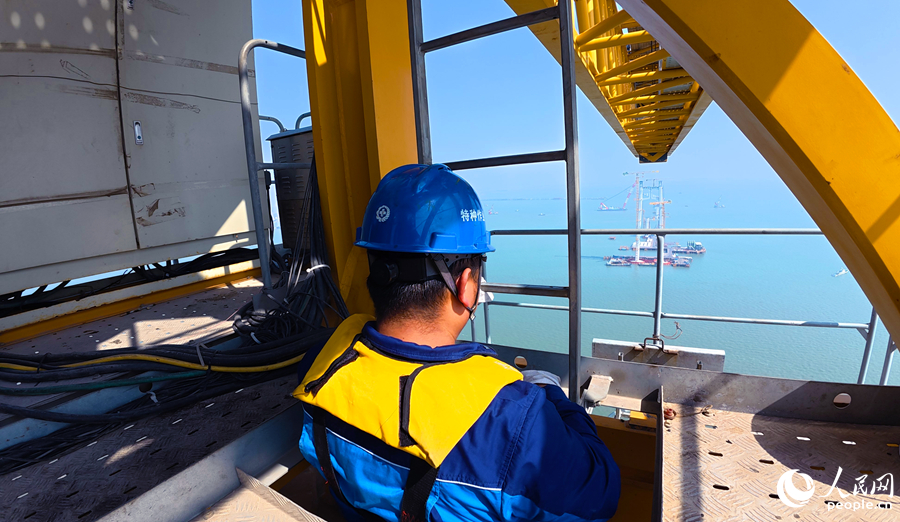 塔吊司机沿爬梯攀爬至200米高空驾驶室，在“云端”建大桥。人民网记者 李昌乾摄