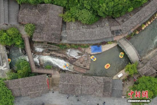 5月12日，江西资溪县大觉山，游客在体验峡谷漂流时经过大觉古镇。(无人机照片)中新社记者 刘力鑫 摄