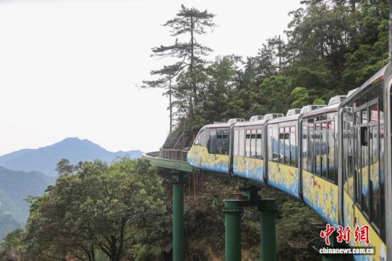 5月12日，江西资溪县大觉山，一辆“悬崖动车”在行驶中，该游览路线全长11.8公里，超三分之一紧贴悬崖，列车穿行在山谷云海间，给游客带来特别的体验。中新社记者 刘力鑫 摄