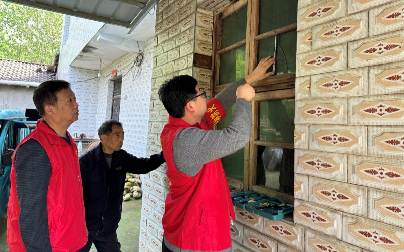 办好“微实事” 服务“大民生” 驻村工作队员和村干部为老人换窗户。