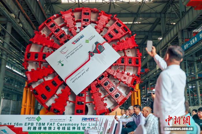 7月2日，由中铁工程装备集团（天津）有限公司研制的中国首台出口沙特阿拉伯大直径土压平衡盾构设备“中铁1079号”通过验收顺利在天津东疆综合保税区下线。该设备刀盘开挖直径11.16米，整机总长105米，将用于沙特阿拉伯利雅得市（Riyadh）地铁二号线延长线项目施工。图为参加下线仪式的嘉宾用手机拍摄“中铁1079号”盾构机做旋转演示。中新社记者 佟郁 摄