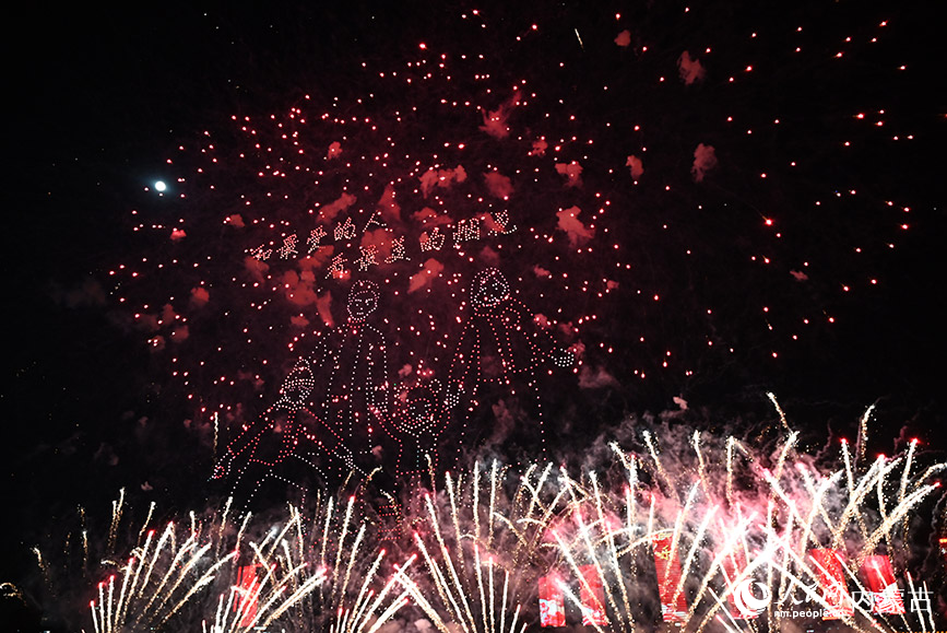 内蒙古鄂尔多斯:“科技范儿”点亮元宵夜 无人机与绚烂烟花在夜空中交相辉映。人民网记者 刘艺琳摄
