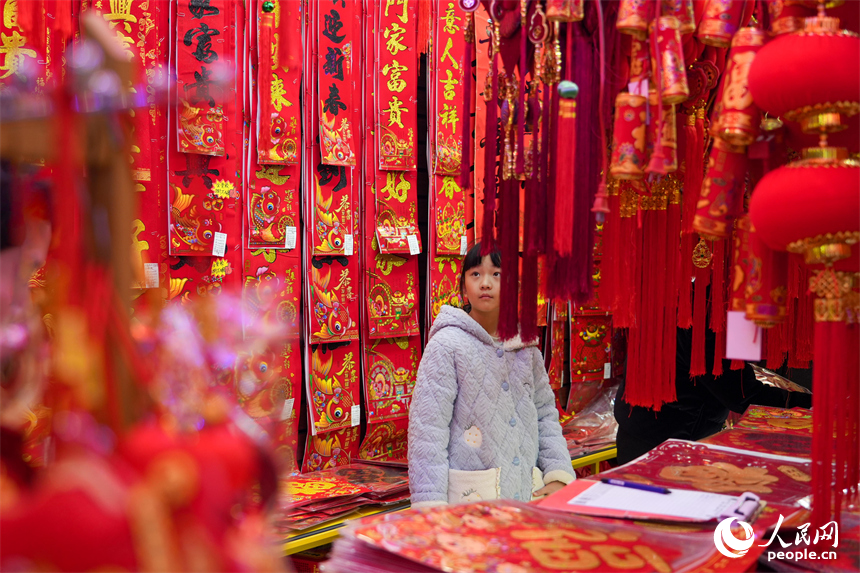 新春走基层|洪城年味浓 采买正当时 市民在年货店内精心挑选新春装饰。 人民网 涂诗轩摄