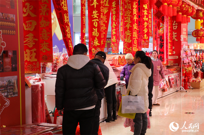 新春走基层|洪城年味浓 采买正当时 市民在年货店内精心挑选新春装饰。 人民网 涂诗轩摄