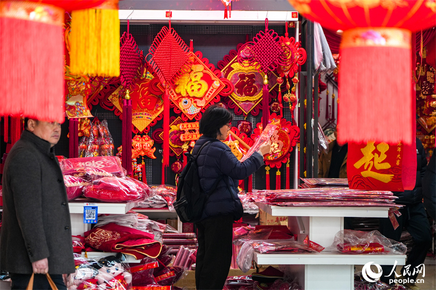新春走基层|洪城年味浓 采买正当时 市民在年货店内精心挑选新春装饰。 人民网 涂诗轩摄