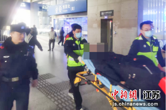 民警护送突发疾病的旅客前往救护车。南京铁路公安处南京站派出所 供图