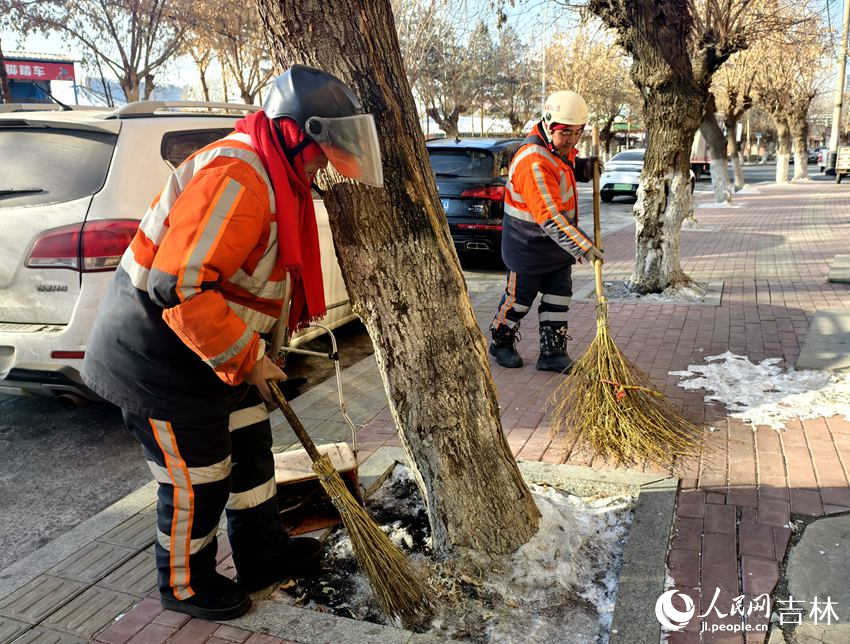 新春走基层|守好1.2平方公里的洁净 姜丽君叫来环卫工人清理黏在雪里的垃圾。人民网记者 关思聪摄