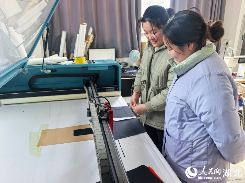 张宪正教徒弟操作激光切割机。人民网记者 周雯摄